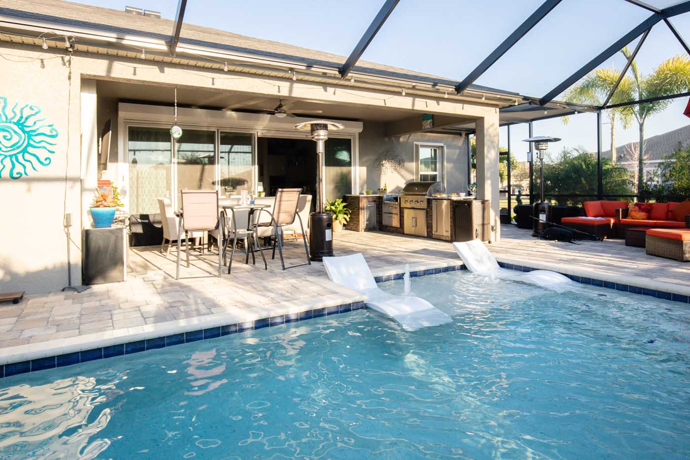 a beautiful summer kitchen next to a covered pool