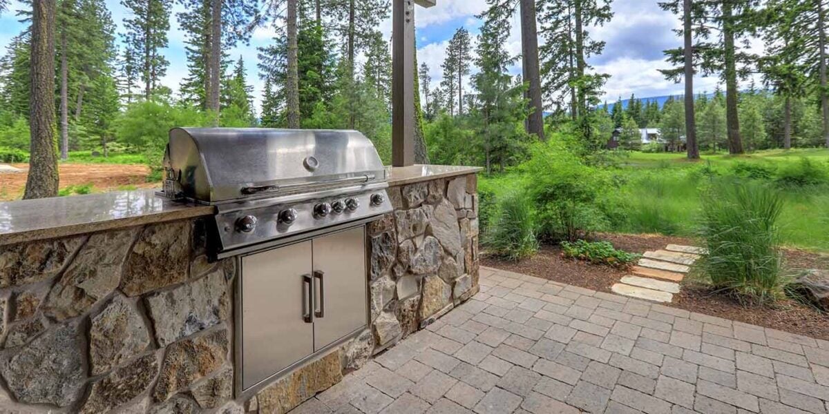 a stone outdoor kitchen with a natural veneer