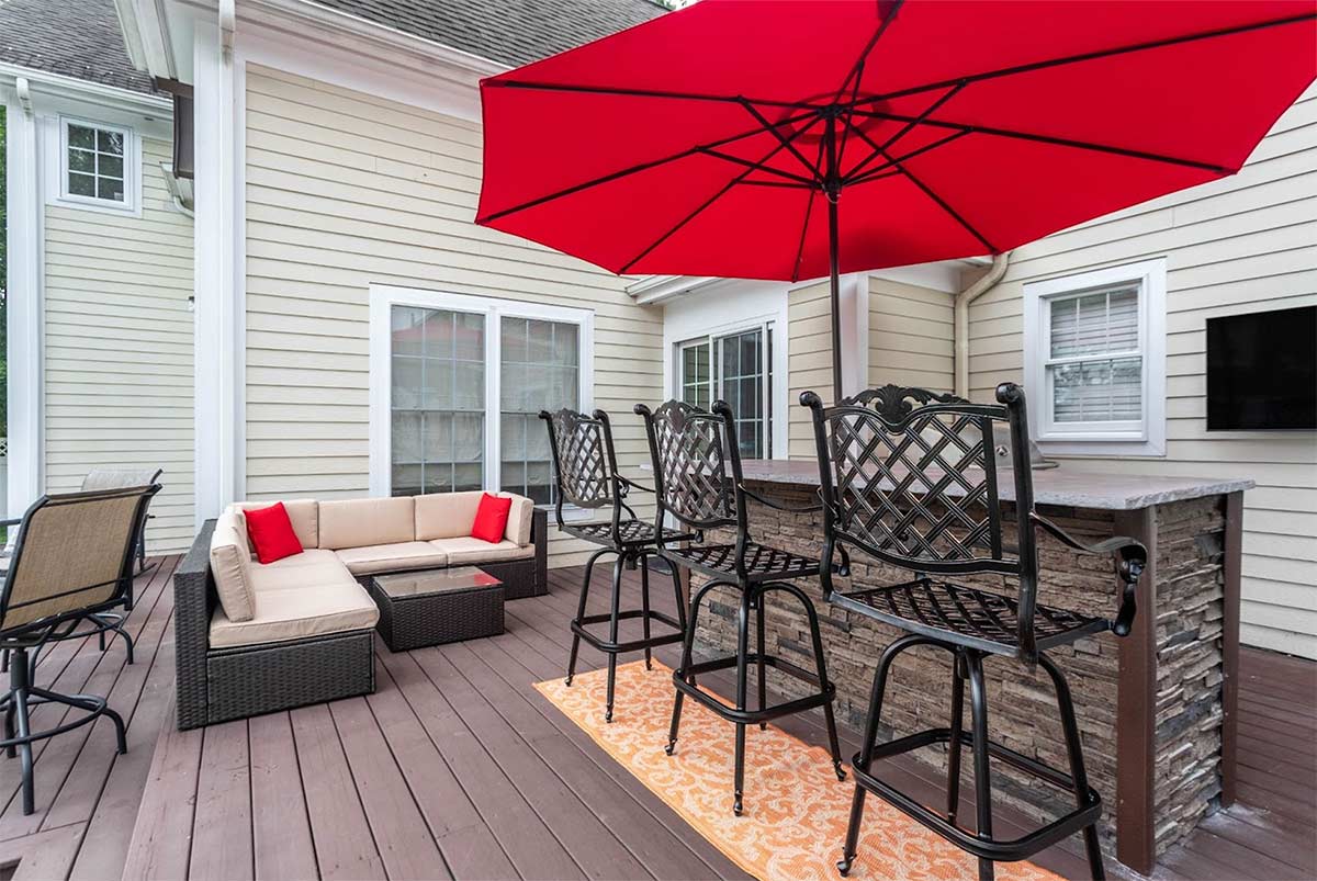 bar island with seating under an umbrella on deck