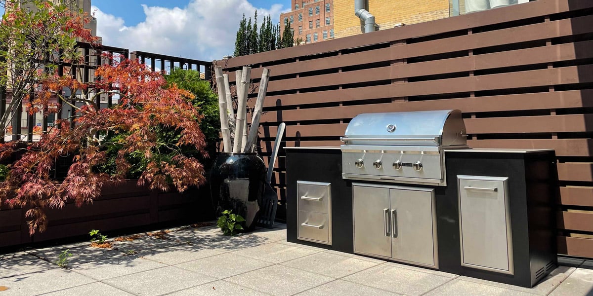black urban outdoor kitchen in small space with privacy wall