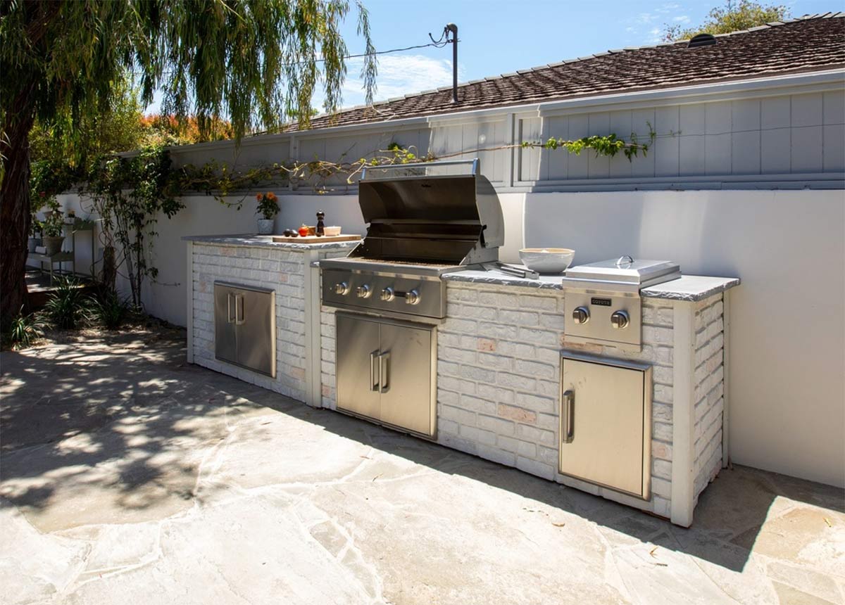 flagstone patio idea with brick outdoor kitchen