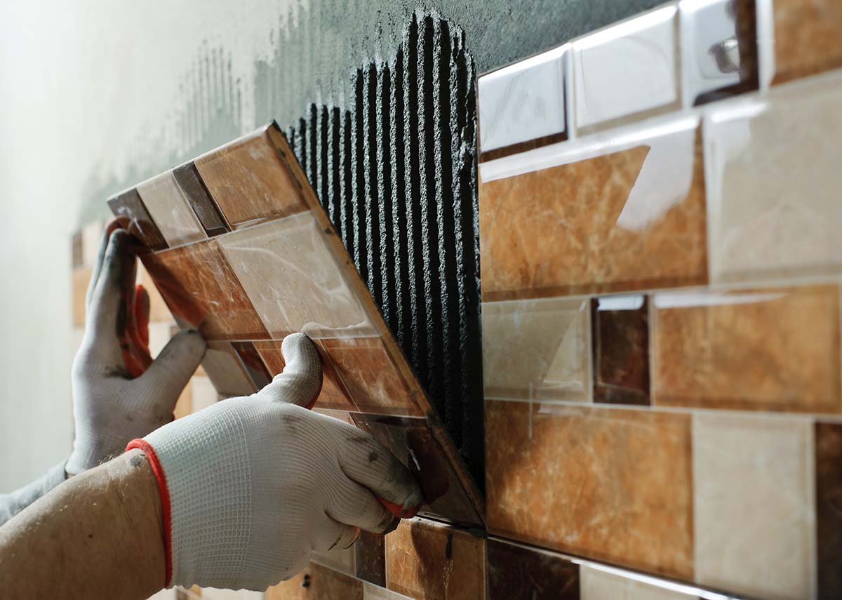 ceramic tiles being installed for an outdoor kitchen structure