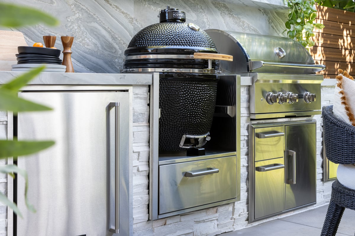 close up of stone outdoor kitchen with kamado smoker