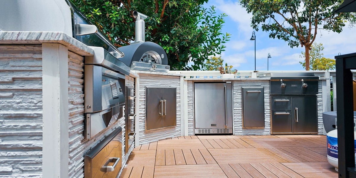 close up angle of modern stone outdoor kitchen with pizza oven