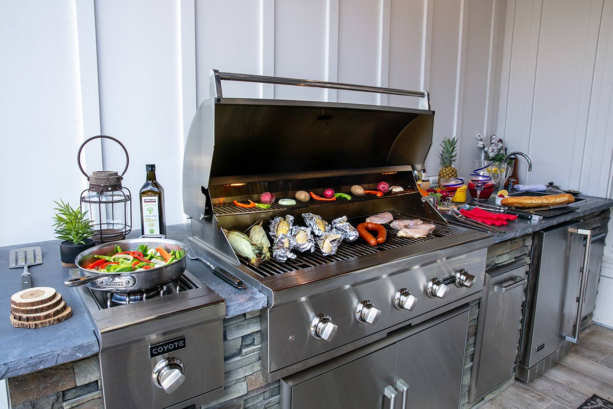 close up of grill with popular grill food items being cooked on it
