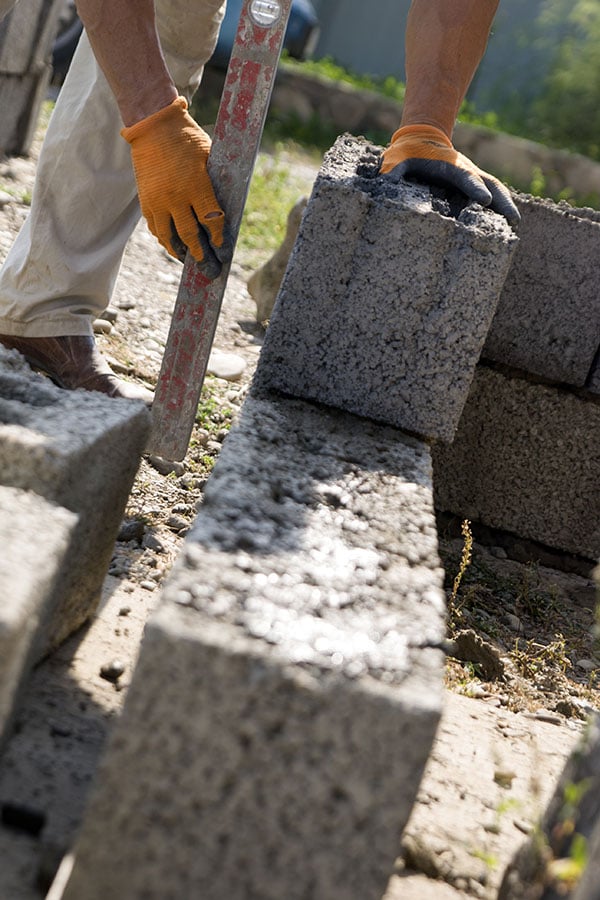 contractor laying out the structure of a cinderblock outdoor kitchen