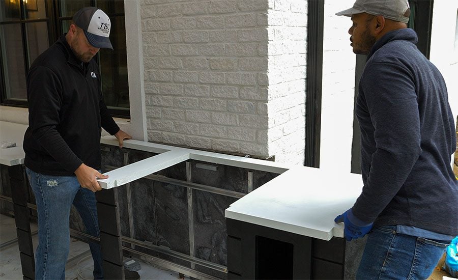 contractors installing a concrete countertop on an rta outdoor kitchen
