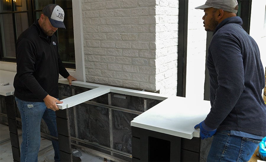 contractors installing a concrete countertop on an rta outdoor kitchen