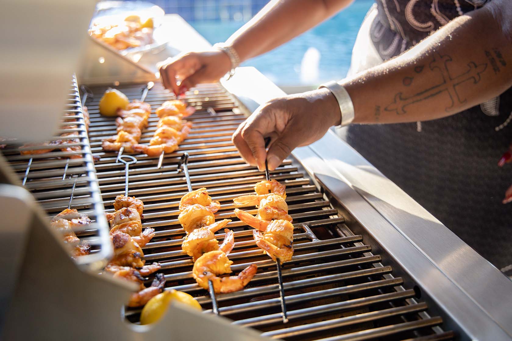 couple cooking shrimp on their coyote grill