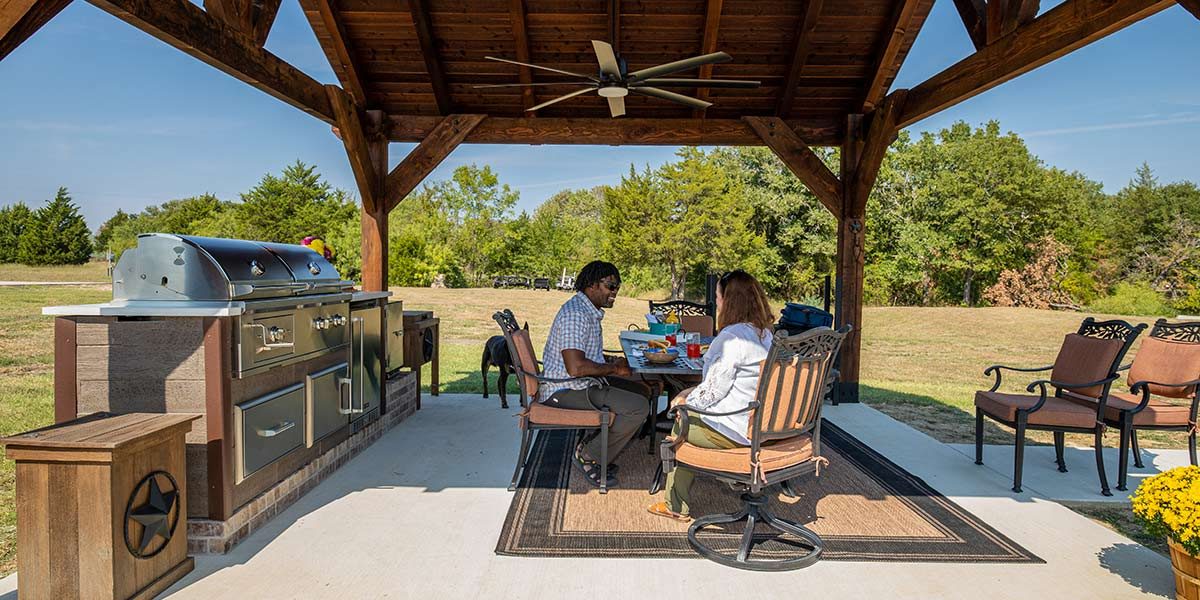 couple sitting next to their outdoor kitchen in dallas