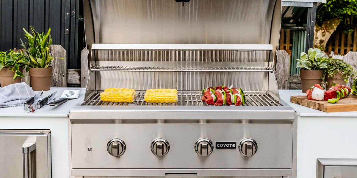 coyote brand built in barbecue grill with corn and kabobs