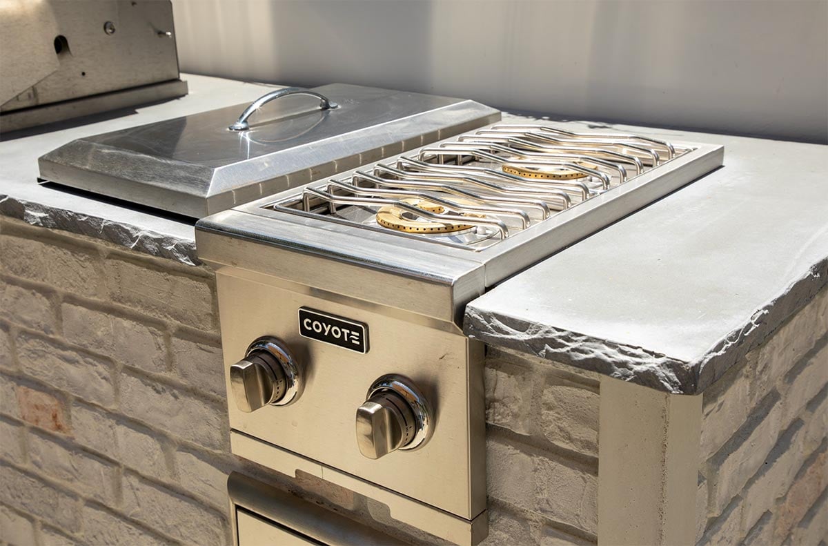 dual side burner in reclaimed brick outdoor kitchen