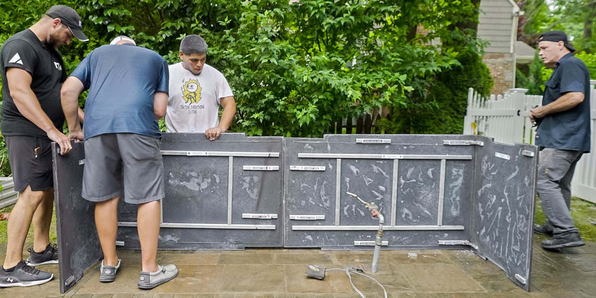 four men assembling an outdoor kitchen