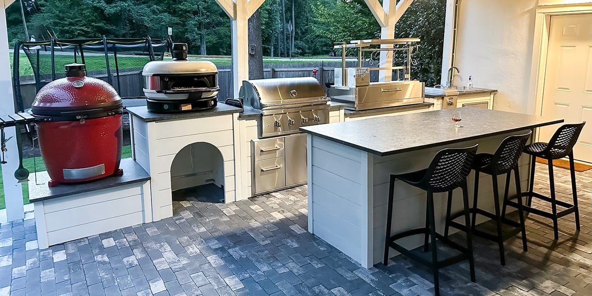 galley outdoor kitchen with kamado smoker pizza oven and argentinian grill
