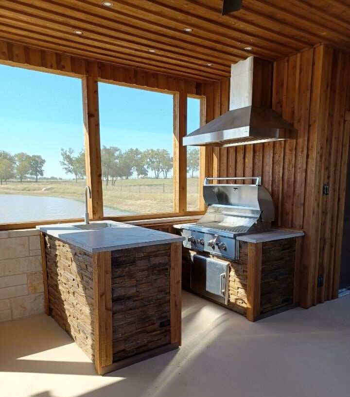galley style outdoor kitchen in sun room with wall mounted vent hood
