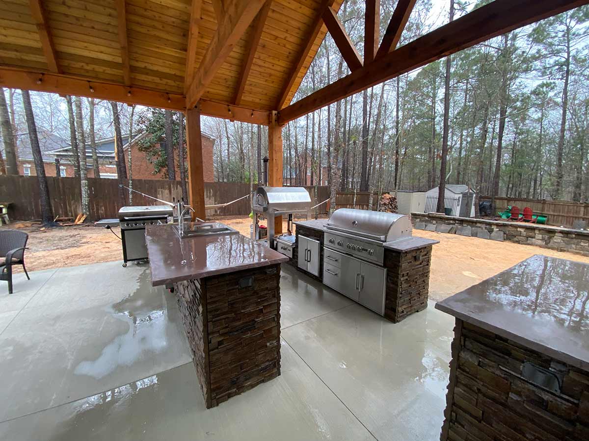 galley style outdoor kitchen with combo storage refreshment center and storage on patio under gazebo in stacked stone terra finish