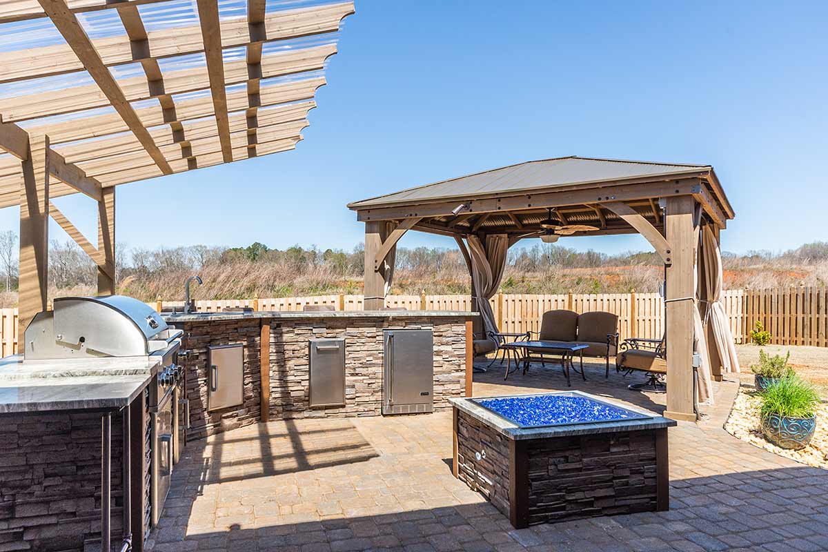 gazebo next to outdoor kitchen with seating area