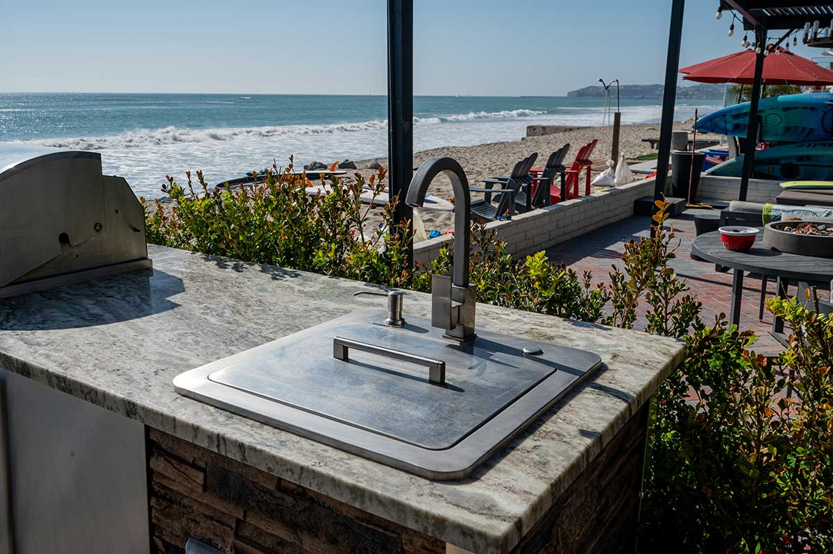 granite countertop with sink in a grill island and the beach right in the backyard