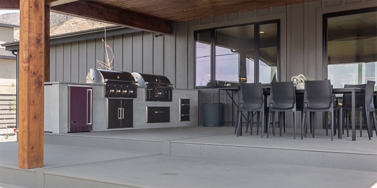 grayscale backyard design with outdoor kitchen and dining table