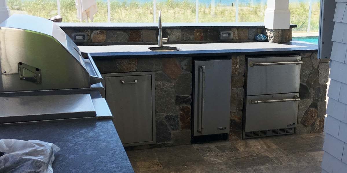 hand laid stone outdoor kitchen by pool ready to use