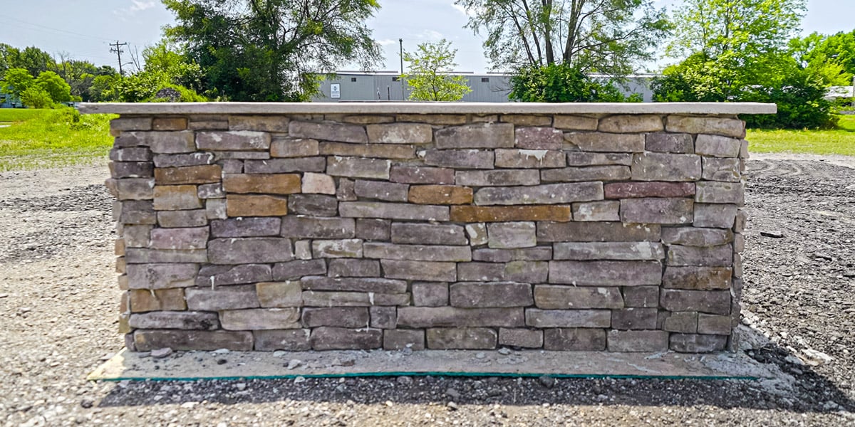 hand stacked stone outdoor kitchen on gravel