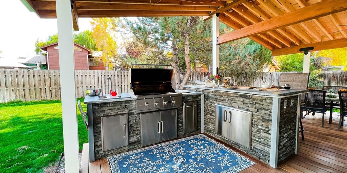 l shape outdoor kitchen with rug on deck under pavilion