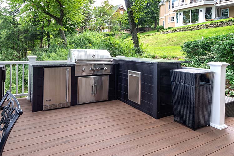 l shape rta outdoor kitchen with dark plank finish built on a deck