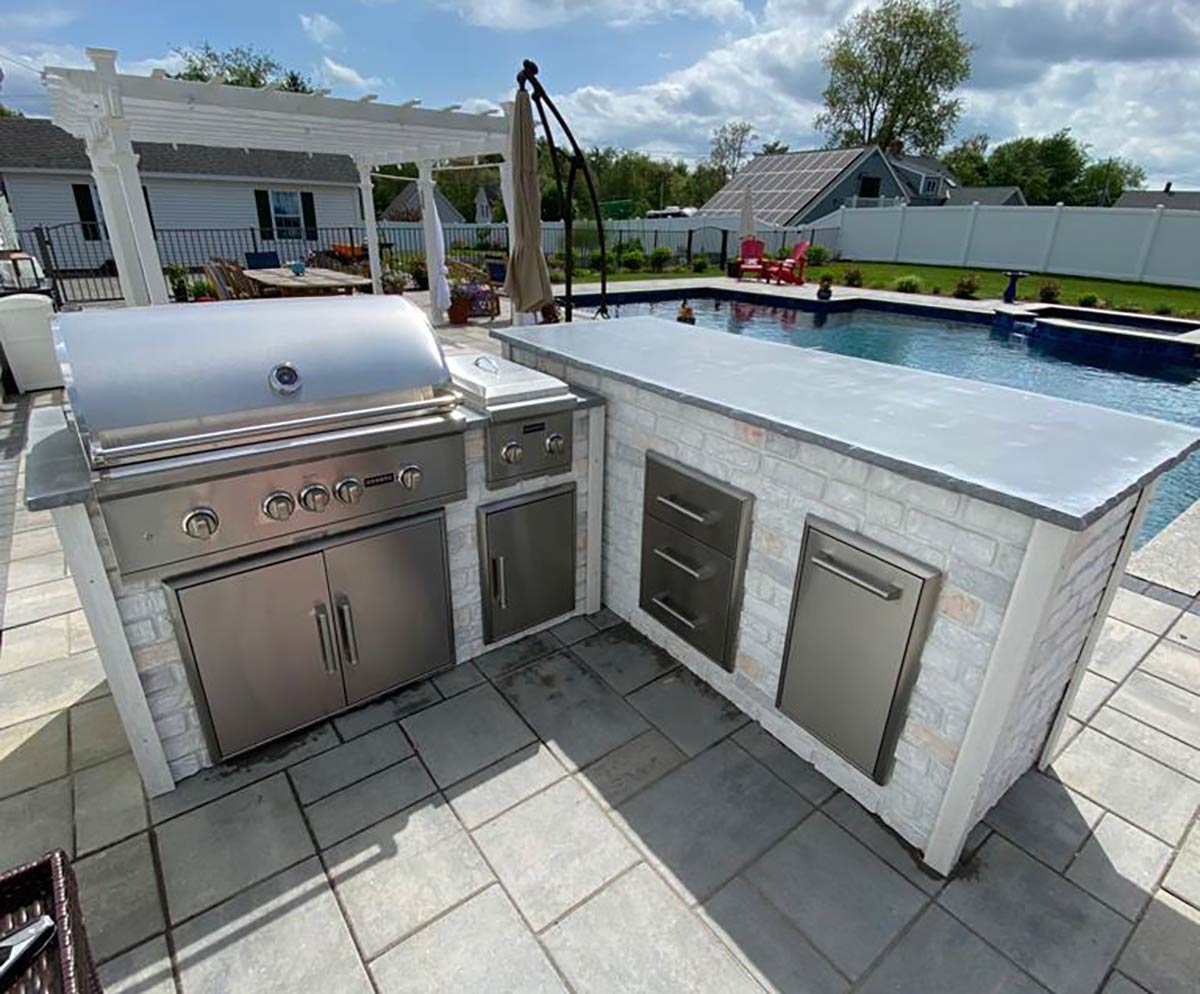 Traditional luxury l shaped grill island with dual burner and double access doors on patio in reclaimed brick finish