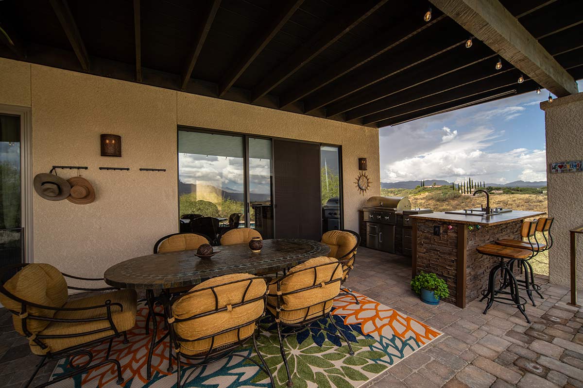 l shaped outdoor grill island on deck with dining table