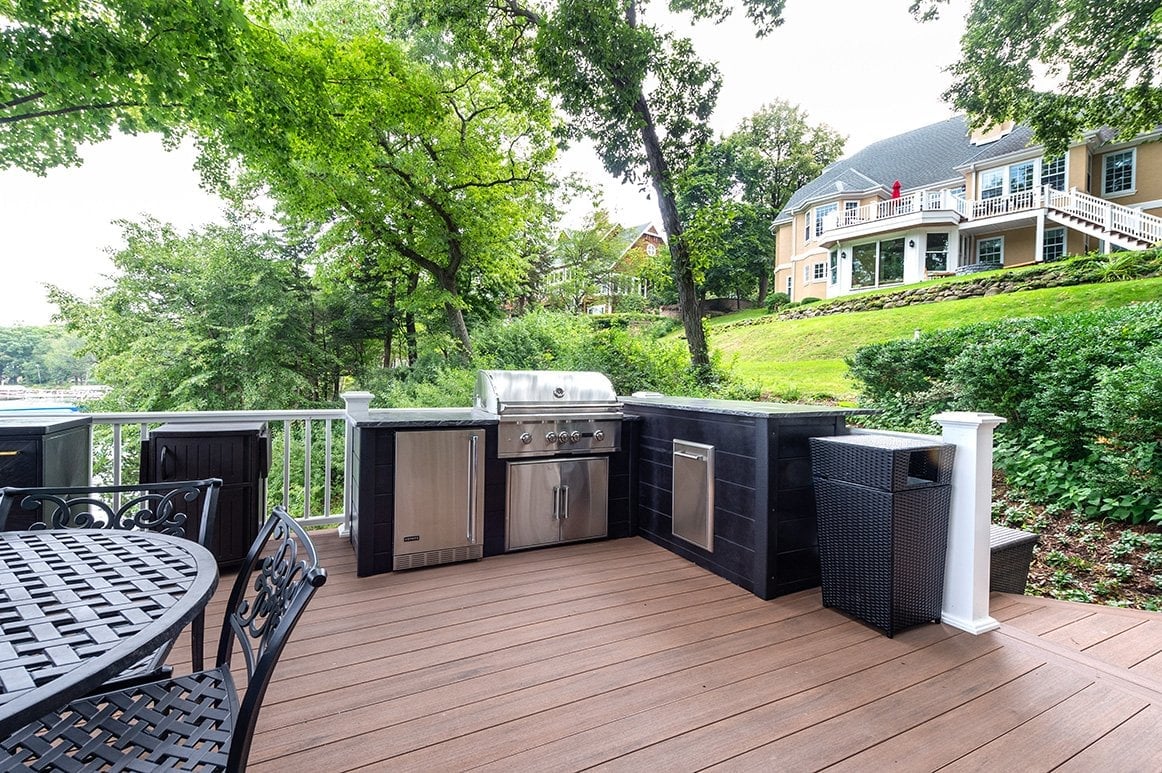 l-shaped outdoor kitchen on deck with black plank style finish