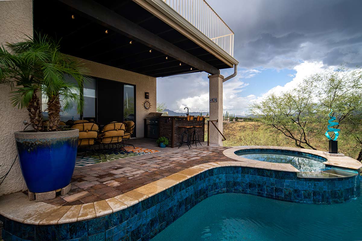 l shaped outdoor kitchen on patio by pool