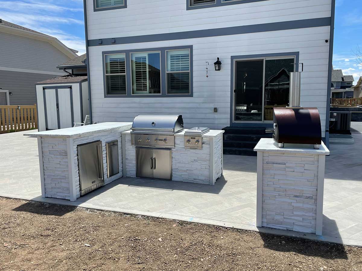 Outdoor grill station with pizza oven galley style to create more space