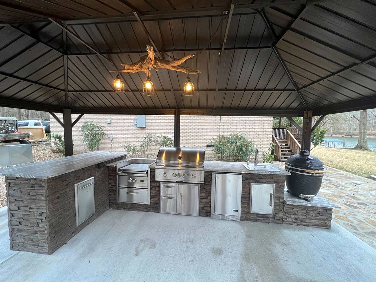 Outdoor grill and smoker station under a large gazebo with all the accessories