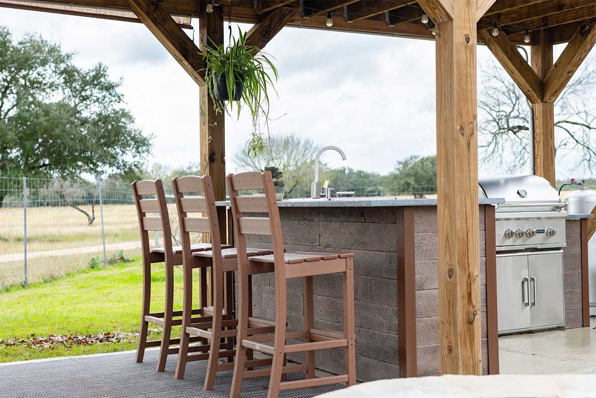l shaped outdoor kitchen bar under pergola