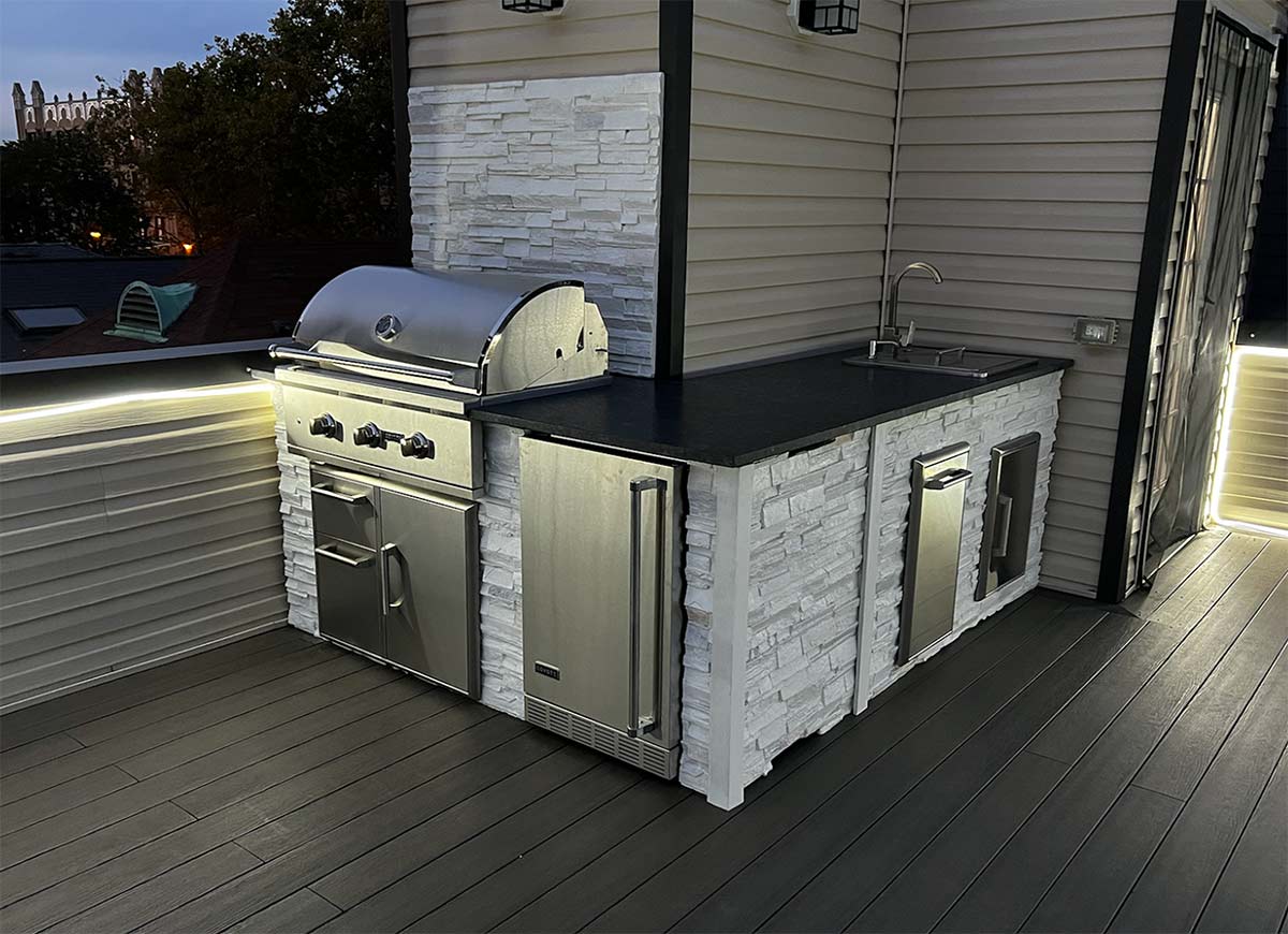 l shaped outdoor kitchen with stone backsplash