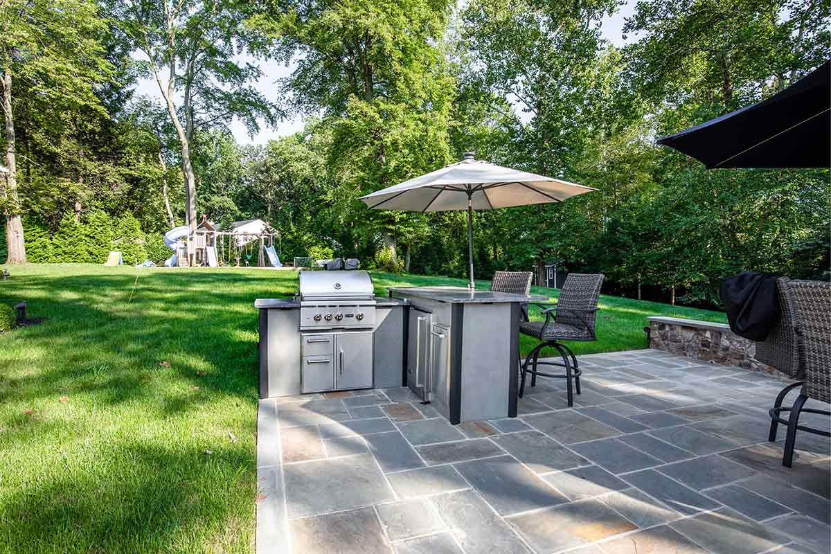 rta l shaped bbq with bar and umbrella on patio