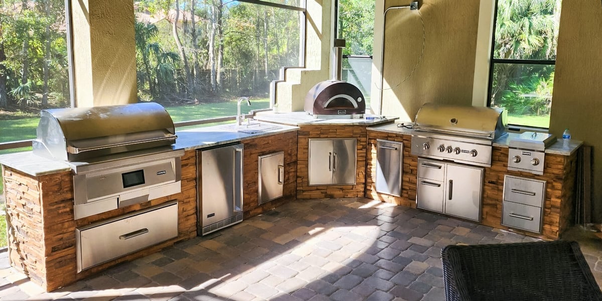 l shaped stone outdoor kitchen with pellet grill pizza oven and gas grill