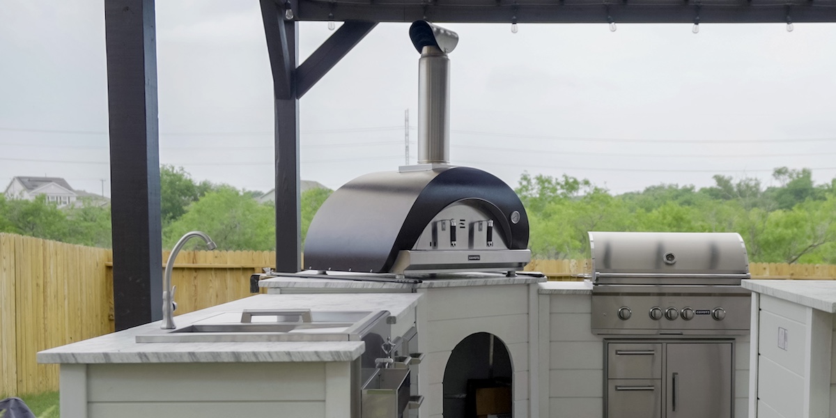 large outdoor kitchen with pizza oven and grill