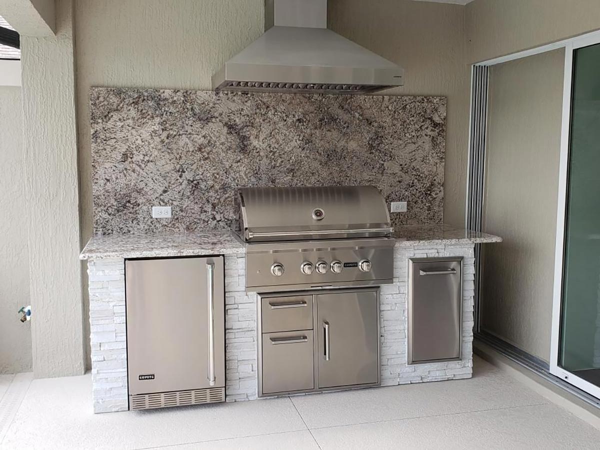 linear grill island next to wall with vent hood