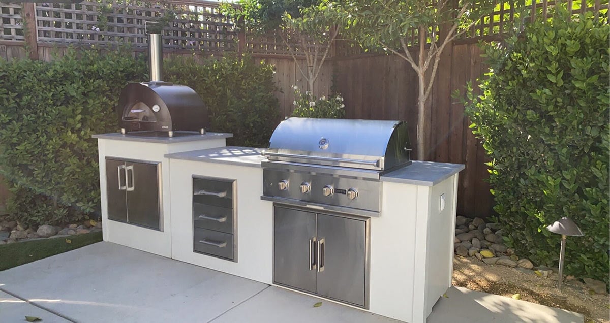 linear modern concrete moks outdoor kitchen with pizza oven