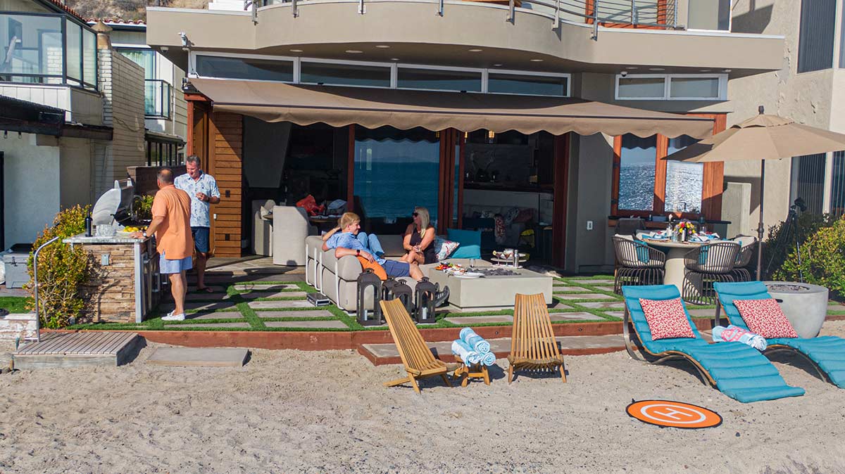 linear outdoor kitchen on patio by beach with glass doors connecting inside space to outside