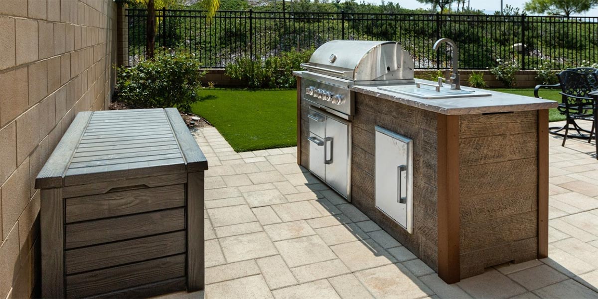 linear outdoor kitchen on patio with weathered wood finish