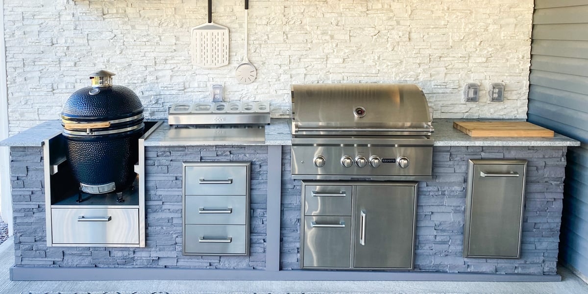 linear outdoor kitchen with gas grill smoker and backsplash