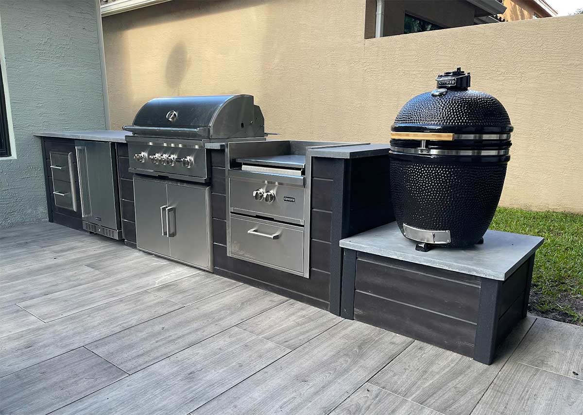 linear outdoor kitchen with double drawers, grill, power burner and coyote asado smoker