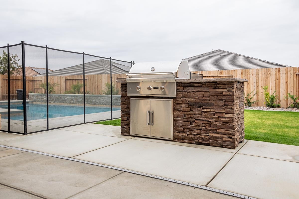 linear small backyard kitchen with storage by a pool