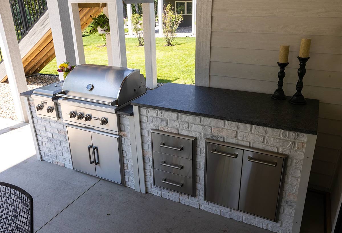 linear outdoor kitchen with storage drawers and pull out trash and recycling