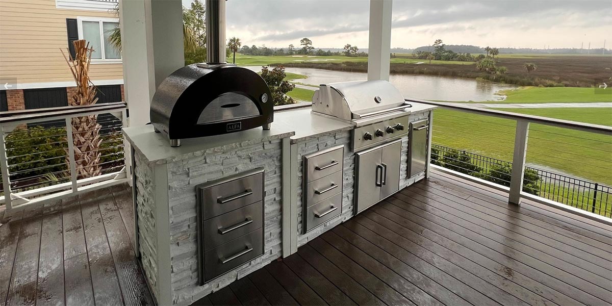 linear stacked stone chalk grill island on a deck with dining table 1