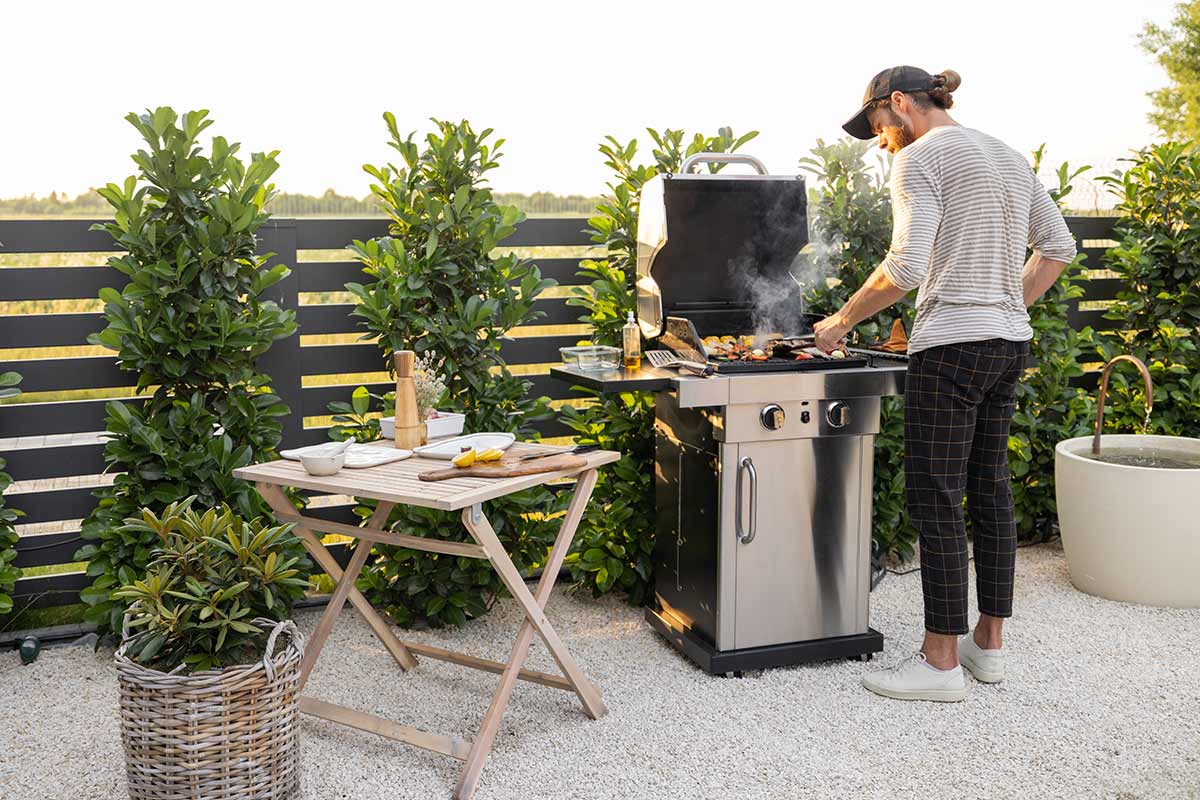 Consider an outdoor grill station to upgrade from a grill cart unlike the person shown grilling