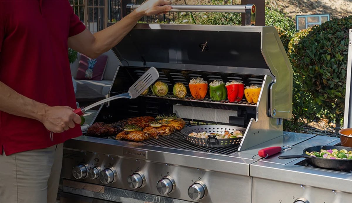man cooking on a kitchenaid stainless steel grill