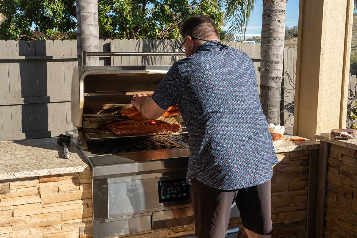 man grilling ribs on pellet grill